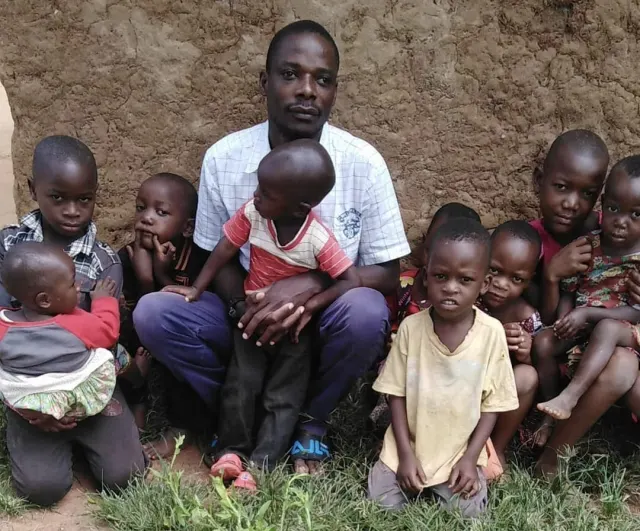 Suleiman sitting with a group of young children at New Hope
