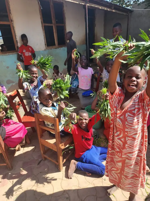 Children holding fresh vegetables from the garden